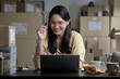 © amenic181 - Smiling young  Asian woman online seller taking note of orders from customers. Dropshipping business owner working in her store warehouse.