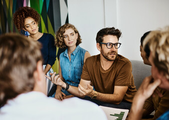 Poster - Exploring the possibilities. Shot of a group of designers having a discussion in an office.