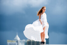 Beautiful Woman In Elegant Dress On The Sky. Female Model In A Fashion Dress Outdoor.
