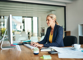 Poster - Shes focused on the task at hand. Cropped shot of a mature businesswoman working on her computer in a corporate office.