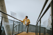 Young Short Hair Business Woman Walking On Office Stairs And Holding Laptop