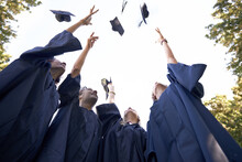 Our Hard Work Has Paid Off. A Group Of College Graduates Celebrating By Throwing Their Hats In The Sky.