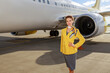 © Friends Stock - Stewardess or air hostess standing near aircraft at airport