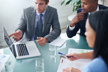 Poster - Presenting his results to the team. Shot of a businessman showing his colleagues something on a laptop during a meeting.
