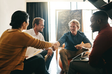 Poster - In it for the betterment of business. Shot of designers shaking hands during a meeting in an office.