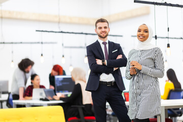 Two multiethnic colleagues in a modern office space. Group of people working in the background Diversity and success concept..