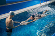 © Svitlana - Coach helping to young woman in pool