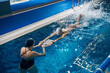 © Svitlana - Coach showing lady how to swim in pool