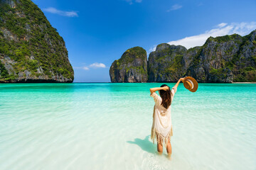 Wall Mural - Young woman traveler relaxing and enjoying at beautiful tropical white sand beach at Maya bay in Krabi, Thailand, Summer vacation and Travel concept