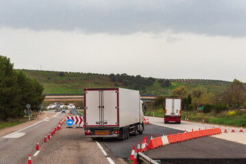 Canvas Print - Refrigerated trucks changing lanes on a highway closed for works.