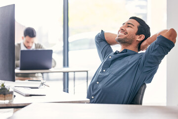 Poster - It feels good to be done for the day. Shot of a handsome young businessman sitting in the office with his arms behind his head in relief.