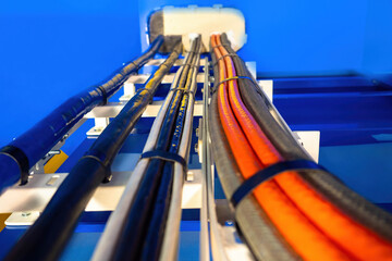 Poster - electrical wiring. orange and black cables on blue background. wires are secured with plastic ties. 