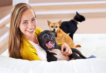 Wall Mural - I guess Im an animal person. Portrait of an attractive young woman sitting with her pets on the sofa.