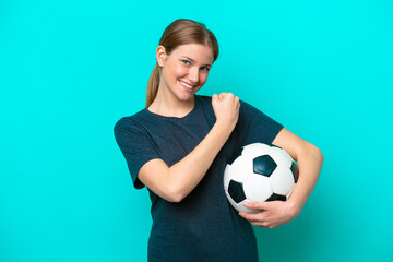 Wall Mural - Young football player woman isolated on blue background celebrating a victory