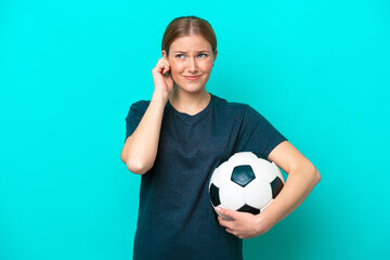 Wall Mural - Young football player woman isolated on blue background frustrated and covering ears