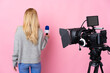 © luismolinero - Reporter woman holding a microphone and reporting news over isolated pink background in back position