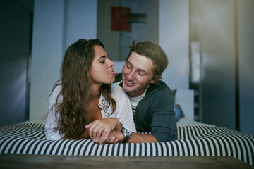 Poster - We can have fun all by ourselves. Shot of an affectionate young couple lying on bed.