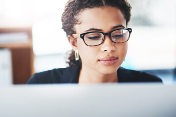 Poster - Lets see what we have here. Shot of a young businesswoman working on a computer in an office.
