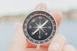 © Victor - Hand holding a compass in front of the sea, concept of adventure, travel, selective focus.