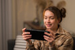 © Anton - A fair-haired girl with a portable game console in her hands. Mobile games, video games, modern technologies, cyberspace, communication, entertainment. Close-up.