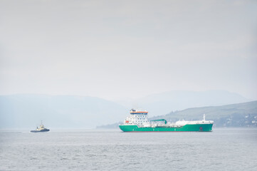 Wall Mural - Ship transporting floating storage container platform in sea followed by tugboat