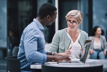 The team that has what it takes. Shot of a businessman and businesswoman using a laptop during a meeting at a convention centre.