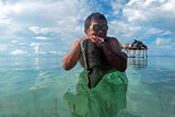 Fototapeta Do akwarium - Portrait of Bajau Laut or Sea Gypsy man on a boat with scuba glass in Maiga island Semporna Sabah Malaysia