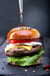 Delicious burger on dark wooden surface isolated on black