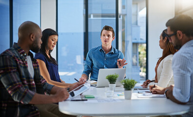 Taking note and thinking ahead. Shot of a group of young businesspeople discussing ideas with each other during a meeting in a modern office.