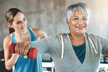 The Healthy Heart Is A Youthful Heart. Shot Of A Senior Woman Using Weights With The Help Of A Physical Therapist.