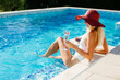 © shevtsovy - happy woman relax in swimming pool on summer vacations. Sexy woman in swimsuit splashing water drops and having fun. Summer vacation time.