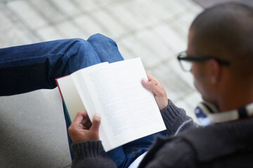 Aufkleber - Reading up on notes for his next lecture. Cropped shot of a college student reading a book while sitting outside at campus.