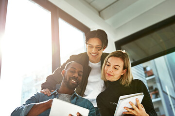 Wall Mural - Brainstorming made simple with wireless technology. Shot of a group of young businesspeople brainstorming with a tablet in the office.