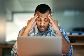 Sticker - Stressed out. Cropped shot of a young businessman looking stressed while working in the office.