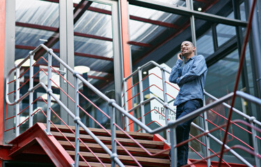 Aufkleber - I got the job. Shot of a handsome young man using his mobile phone while sitting on the steps of an office.
