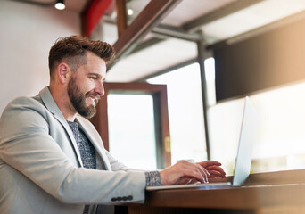 Poster - Hes a man on a mission. Cropped shot of a modern businessman using his laptop in a coffee shop.