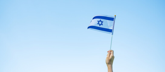 Wall Mural - hand holding Israel flag on nature background. Israel Independence day and happy celebration concepts