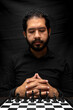 © Narayan - latin man with beard reflecting on chess game, chess concept