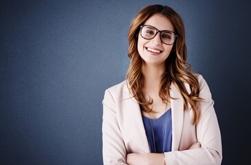 Poster - Confidence creates the success I deserve. Studio portrait of an attractive and confident young businesswoman posing against a dark blue background.