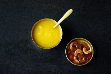 Ghee or clarified butter close up in golden bowl and golden spoon, selective focus