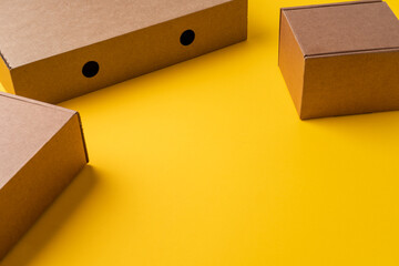 Wall Mural - Beige cardboard boxes on yellow background, close up