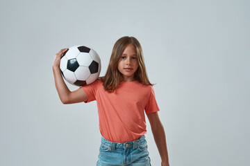 Wall Mural - Front view of little girl holding football ball