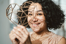 Smiling Woman With Black Curly Hair Holding Heart Shaped Object