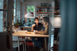 © Westend61 - Man talking with girlfriend sitting at dining table in kitchen