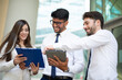 © Minerva Studio - Business people using a tablet outdoor