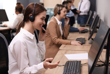 Call Center Operators Working In Modern Office, Focus On Young Woman With Headset