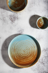 Wall Mural - blue and brown plates on a gray cement background, ceramic. place for text.
