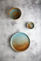 Wall Mural - blue and brown plates on a gray cement background, ceramic. place for text.