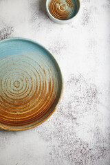 Wall Mural - blue and brown plates on a gray cement background, ceramic. place for text.
