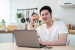 © Kawee - Portrait of Asian young man eating healthy fruit while work from home.